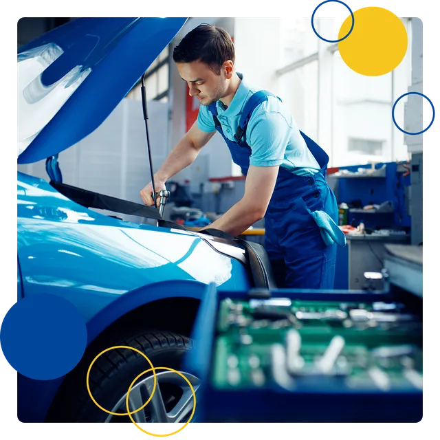 Mechanic working under the hood of a blue car